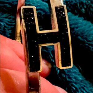 Unbranded black crystal “H” on silver bangle bracelet.